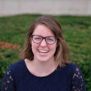 White woman wearing glasses with shoulder length brown hair