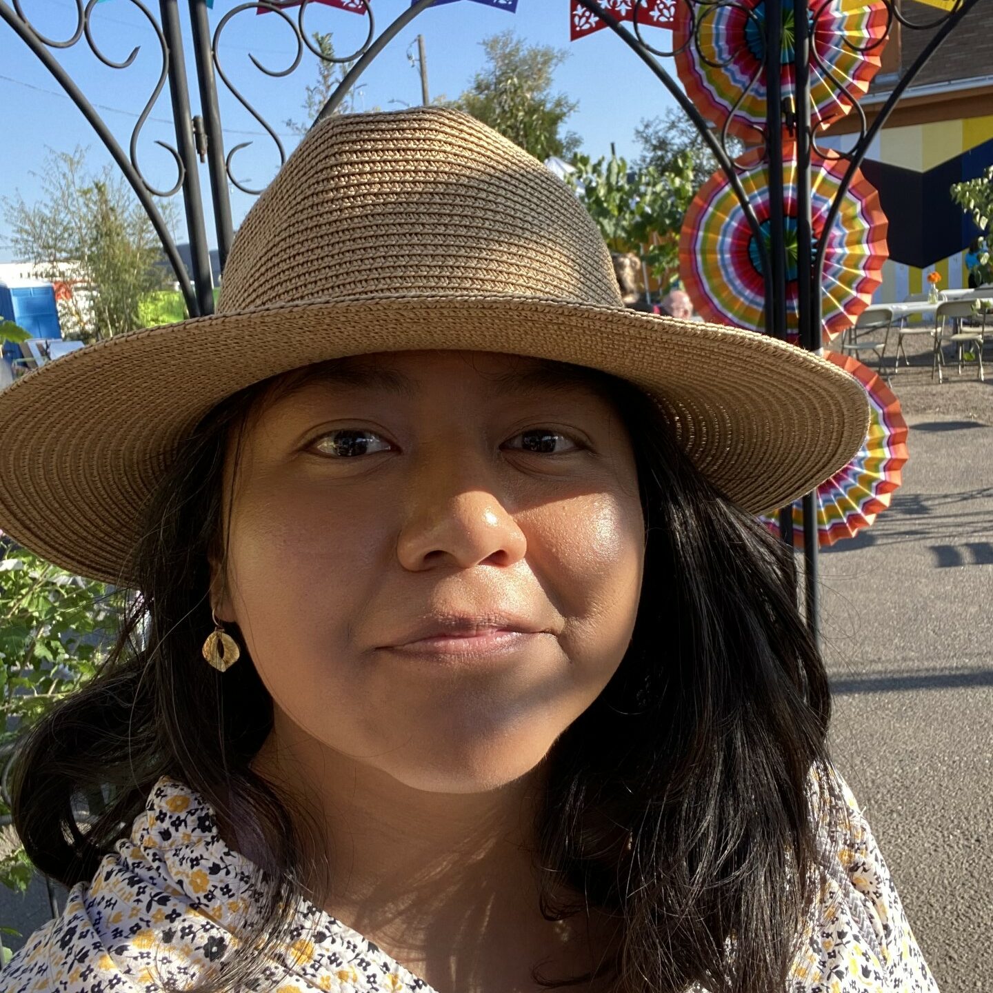 Mexican woman with shoulder length brown hair wearing sun hat