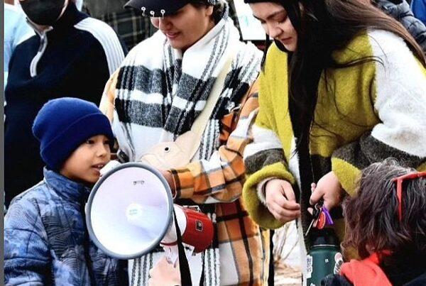 Group of protestors gather around a megaphone