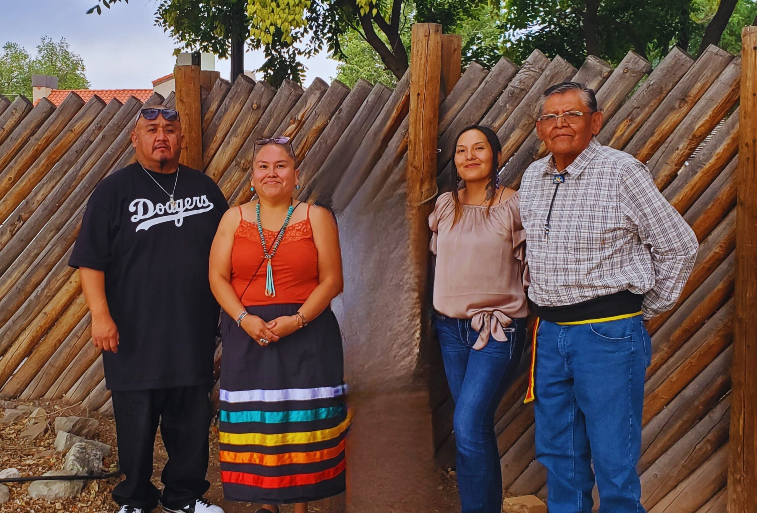 Four Native people pose for a photo outdoors