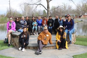 Group of people sitting together in front of creek