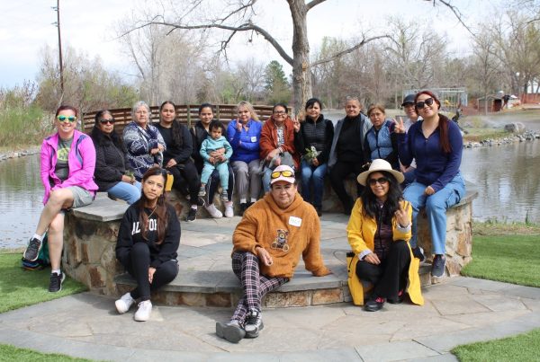 Group of people sitting together in front of creek